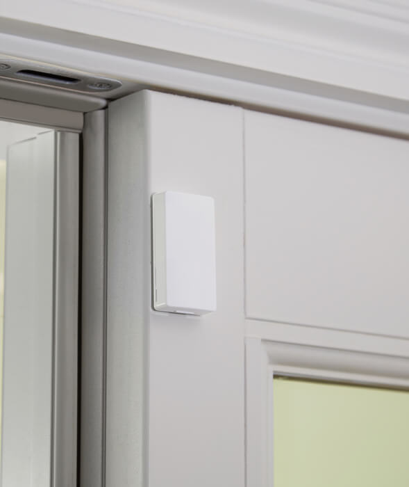 Mini Door/Window Sensor attached to a door with a white frame